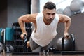 Fit and muscular man doing horizontal push-ups with bars in gym Royalty Free Stock Photo