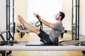 Fit muscular man doing a teaser pilates exercise on a reformer Royalty Free Stock Photo