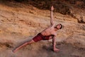 Fit muscular man doing yoga near the mountain. Pilates warrior pose Healthy spine workout. monochrome beige. man Royalty Free Stock Photo