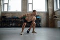 Fit and muscular man lifting kettle bell during exercise class in gym Royalty Free Stock Photo