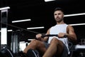 Fit and muscular man using rowing machine at gym Royalty Free Stock Photo