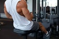 Fit and muscular man using rowing machine at gym. Back view Royalty Free Stock Photo
