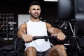 Fit and muscular man using rowing machine at gym Royalty Free Stock Photo