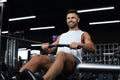 Fit and muscular man using rowing machine at gym. Royalty Free Stock Photo