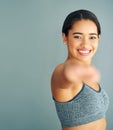 Fit is not a destination, its a way of life. a young woman stretching against a grey background. Royalty Free Stock Photo