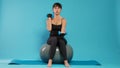 Fit person using dumbbells to lift weights on fitness toning ball Royalty Free Stock Photo