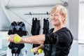 Senior lady staying fit with dumbbell exercise in wireless ems gym Royalty Free Stock Photo