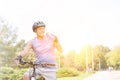 Fit senior man drinking water while riding bicycle in park Royalty Free Stock Photo