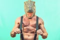 Fit senior man wearing t-rex dinosaur mask - Crazy hipster guy having fun celebrating masquerade carnival holidays