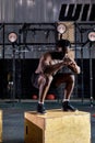 Fit shirtless african athletic man jumping up to plyometric wood box at gym Royalty Free Stock Photo