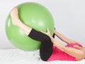 Sport girl lying with large fitness green ball make woman exercice