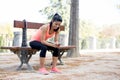 Fit sport woman looking at mobile phone internet app tracking performance after running workout sitting on park bench happy Royalty Free Stock Photo