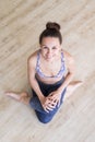 Fit sporty active girl in fashion sportswear sitting on the floor in yoga studio. Active urban lifestyle