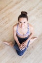 Fit sporty active girl in fashion sportswear sitting on the floor in yoga studio. Active urban lifestyle