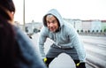 A fit couple runners stretching outdoors on the streets of Prague city. Royalty Free Stock Photo