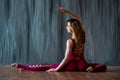 Fit sporty girl is stretching. Young beautiful gymnast woman in a jumpsuit doing gymnastic split, twine.. Sport is a flexible, Royalty Free Stock Photo