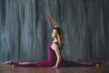 Fit sporty girl is stretching. Young beautiful gymnast woman in a jumpsuit doing gymnastic split, twine.. Sport is a flexible, Royalty Free Stock Photo