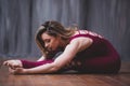 Fit sporty girl is stretching. Young beautiful gymnast woman in a jumpsuit doing gymnastic split, twine.. Sport is a flexible, Royalty Free Stock Photo