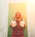 Fit sporty healthy woman on mat in low plank Chaturanga Dandasana yoga pose, doing breathing exercises, watching online yoga class Royalty Free Stock Photo