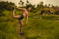 Fit and sporty runner Asian woman stretching leg and body after running workout on green field beautiful background in sport train Royalty Free Stock Photo