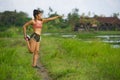Fit and sporty runner Asian woman stretching leg and body after running workout on green field beautiful background in sport train Royalty Free Stock Photo