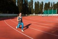 Fit sporty woman doing exercises with the dumbbells at the stadium, empty space Royalty Free Stock Photo