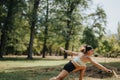 Fit, sporty woman having fun playing badminton outdoors in a park. She enjoys a sunny day, surrounded by trees and Royalty Free Stock Photo