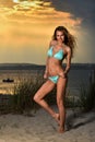 Fit and sporty woman in a swimsuit relaxing on a beach at summer. Royalty Free Stock Photo