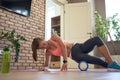 Fit sporty woman rolling on foam massage roller doing exercise at home.