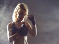 Fit and sporty young girl getting ready for a kickboxing training. Underground gym. Health, sport, fitness concept. Royalty Free Stock Photo