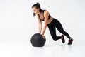 Fit and strong female athlete working out with a medicine ball to get better core strength and stability