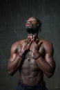 Fit strong physique African American young man under the rain near gray concrete cement wall. Street style concept. Dramatic emoti