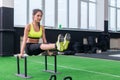 Fit strong woman doing L-sits work-out in gym, lifting up her legs, using parallel bars Royalty Free Stock Photo