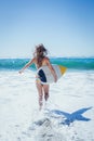 Fit surfer girl running to the sea with her surfboard Royalty Free Stock Photo
