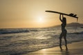 Fit surfgirl on the beach at sunset