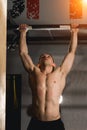 Fit toes to bar man pull-ups bars workout exercise at gym Royalty Free Stock Photo