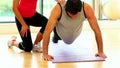 Fit toned man doing pressups in fitness hall