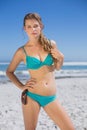 Fit woman in bikini on beach looking at camera Royalty Free Stock Photo