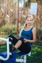 Fit woman in a blue shirt and leggings exercising at outdoors gym playground equipment. fit and sporty woman training outside Royalty Free Stock Photo