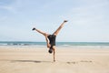 Fit woman cartwheeling on the sand