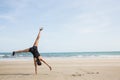 Fit woman cartwheeling on the sand Royalty Free Stock Photo