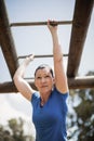 Fit woman climbing monkey bars during obstacle course Royalty Free Stock Photo