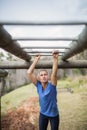 Fit woman climbing monkey bars during obstacle course Royalty Free Stock Photo