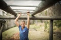 Fit woman climbing monkey bars during obstacle course Royalty Free Stock Photo