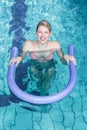 Fit woman doing aqua aerobics with foam rollers Royalty Free Stock Photo