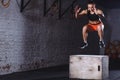 Fit woman doing box jump exercise. Muscular woman doing box jumps at gym Royalty Free Stock Photo