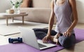 Fit woman doing fitness exercises at home. Online video training. Girl doing exercises and meditate. Royalty Free Stock Photo