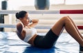 Fit woman doing sit up exercise on mat at boxing studio Royalty Free Stock Photo