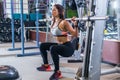Fit woman doing squats with a barbell in Smith machine. Royalty Free Stock Photo