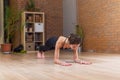 Fit woman doing yoga or pilates exercise standing in plank pose called phalankasana working out on floor in living room Royalty Free Stock Photo